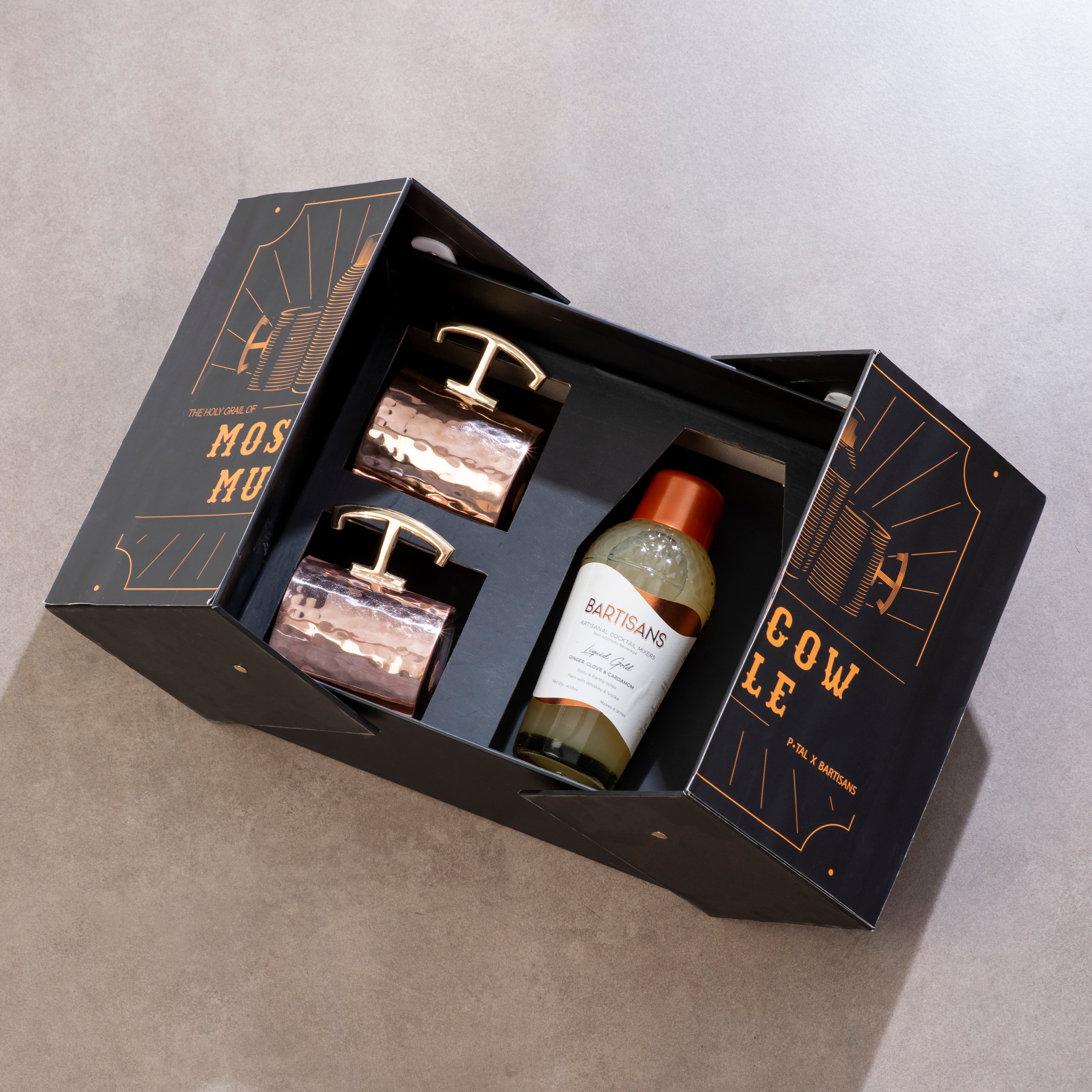 Three items in a black gift box with gold text on a gray background