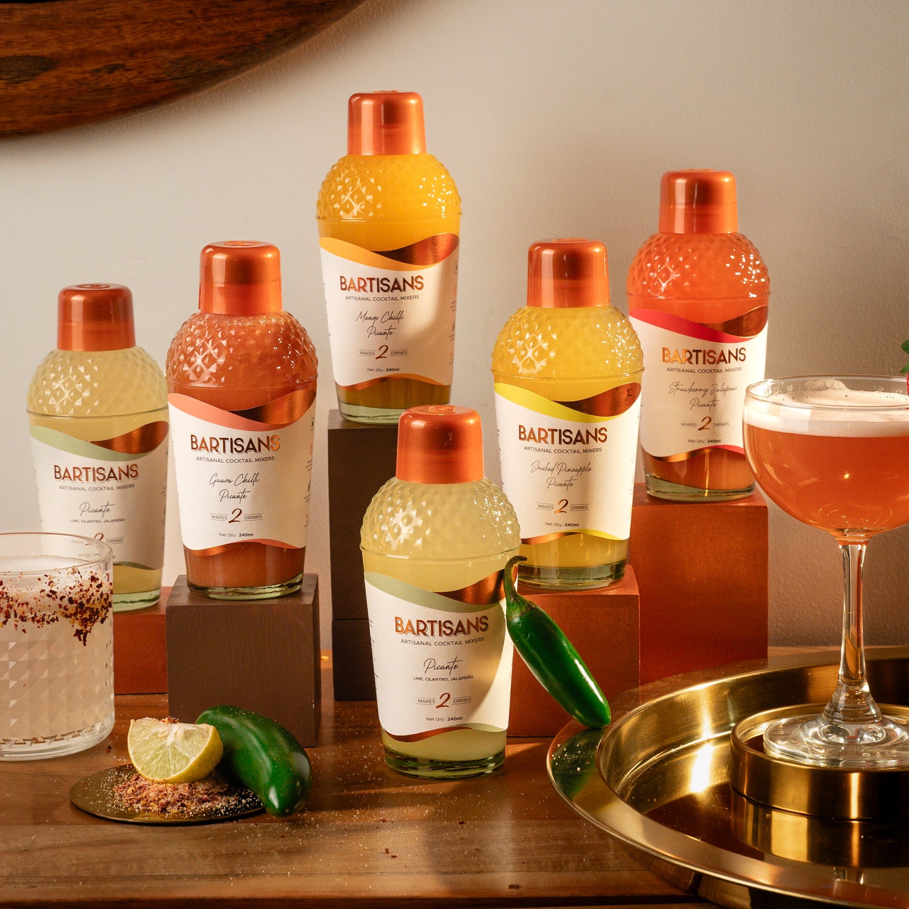 Bartisans picante flavoured drinks with a cocktail and garnish on a wooden surface.