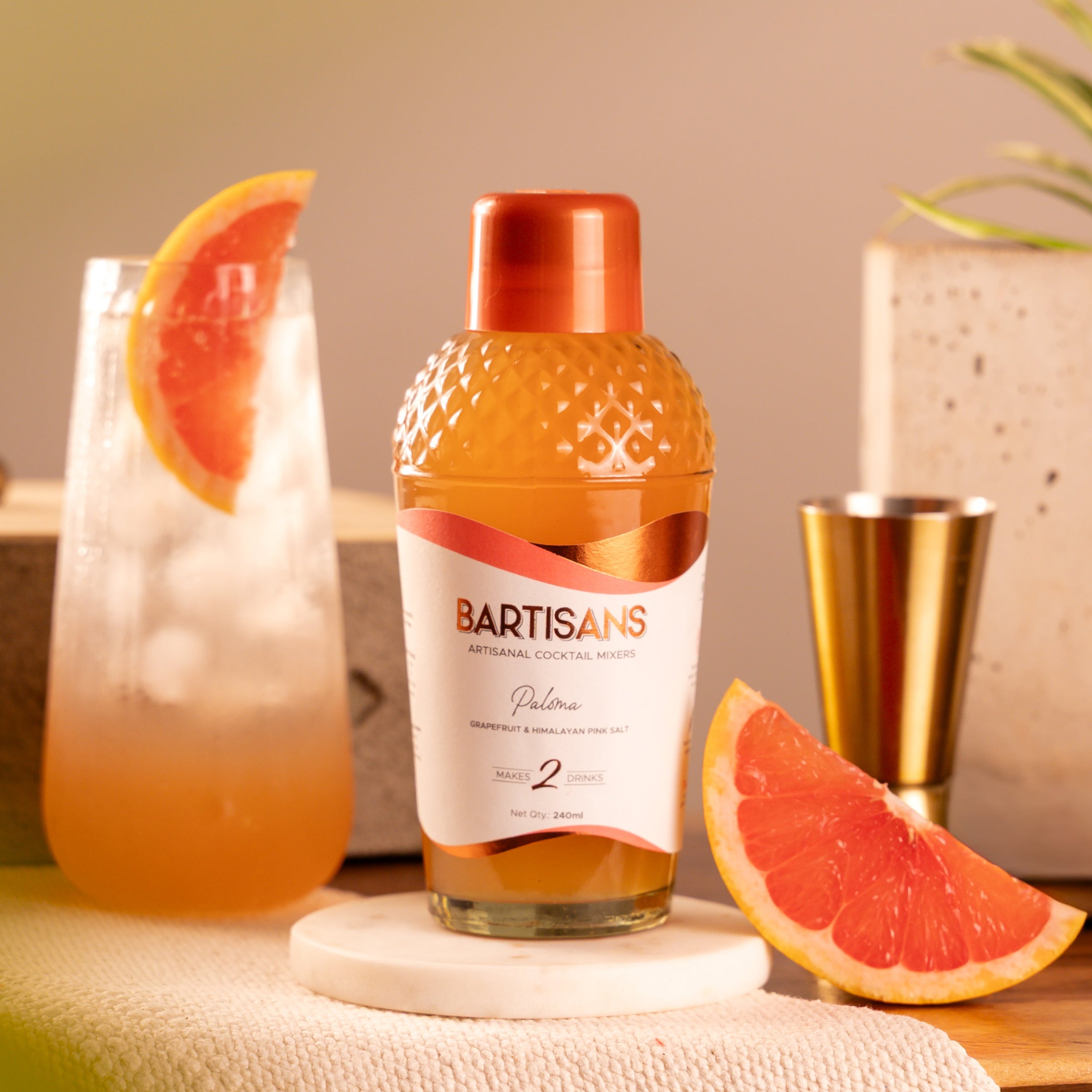  Bartisans Paloma cocktail mixer bottle with a paloma cocktail and grapefruit on a table 
