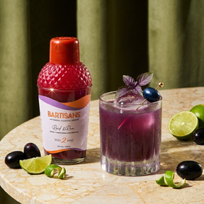 Raid and Run cocktail mixer bottle styled with a poured cocktail