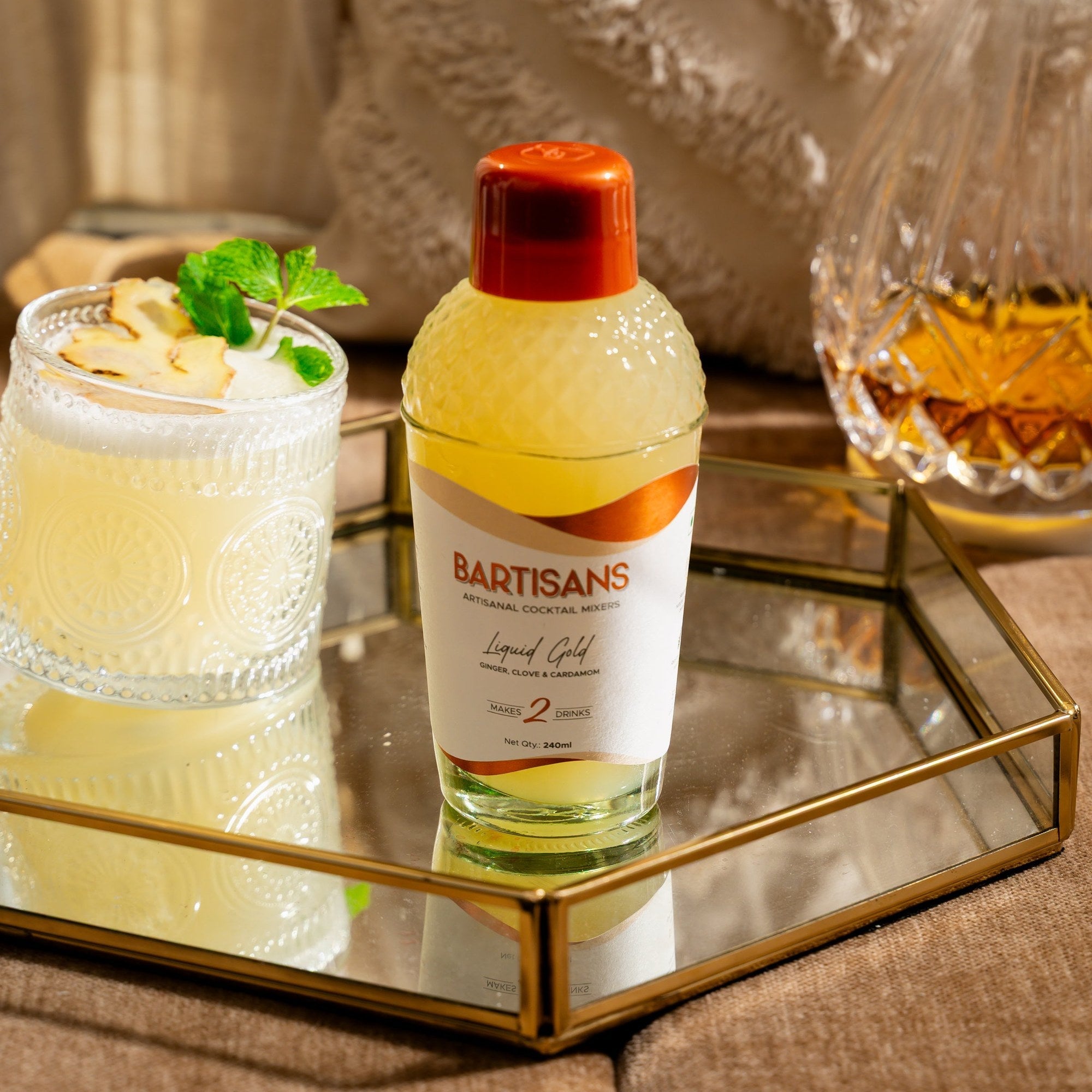  Liquid Gold cocktail mixer bottle styled with a poured cocktail#Serve_2 Drinks 